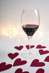Wine glass with hearts bokeh lights on the surface - Valentines Day concept