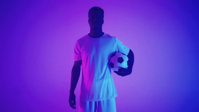 talented black football player is playing with ball in studio, showing skills of dribbling