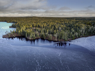 Aerial view of a beautiful frozen lake surrounded by a forest in Halifax, Canada - obrazy, fototapety, plakaty