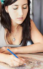 Showcasing her design talents. A female tattoo artist drawing a new design while in her tattoo...