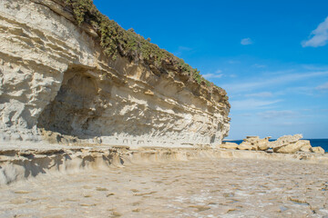 Limestone cliff, notch, wave-cut platform along the coast of Delimara, Malta showing coastal erosion