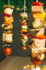 Closeup shot of fresh meat with vegetables on hanging skewers