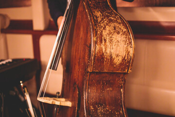 Concert view of an old retro vintage contrabass violoncello  player with vocalist and musical band...