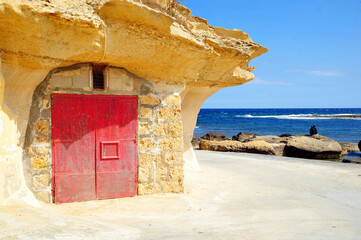 Boathouse with a red door in Gozo Island, Malta