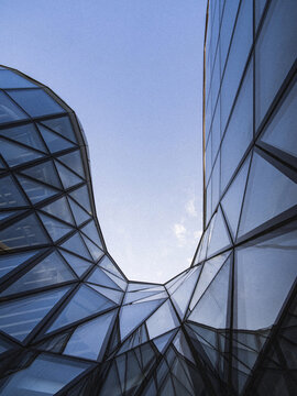 Vertical bottom shot of a ferma construction glass building.