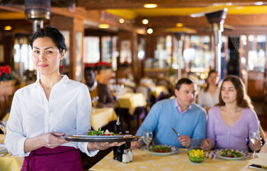 Fototapeta na wymiar Portrait of asian waitress standing in restaurant hall