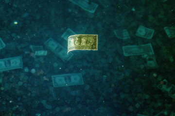 One dollar bill in floating in water alongside  with other coins and money