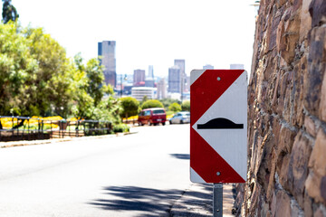 Speed hump ahead sign with the background of the Union Buildings, Pretoria