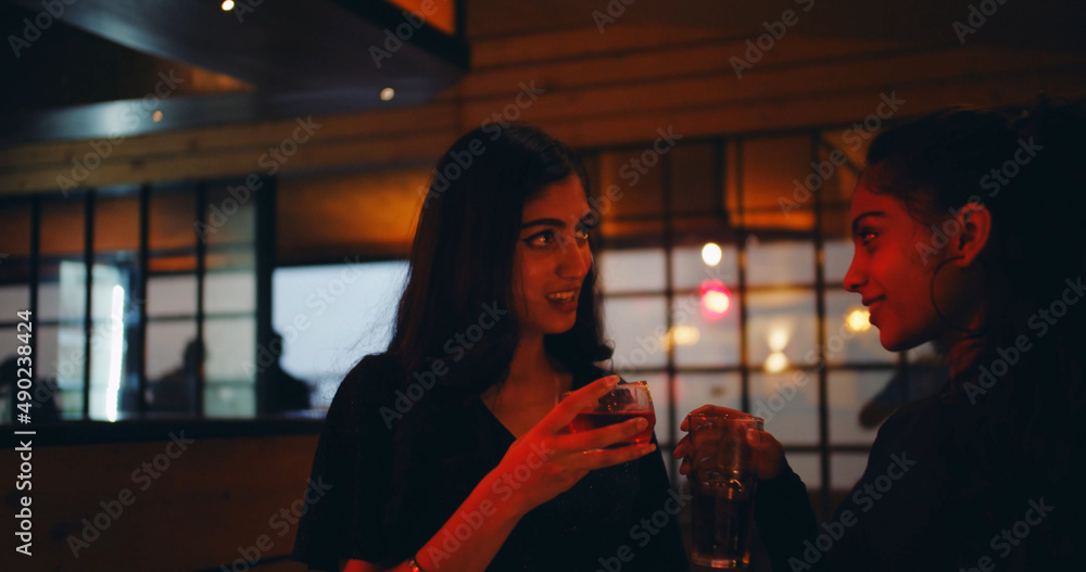 Poster South Asian female friends at a party having drinks