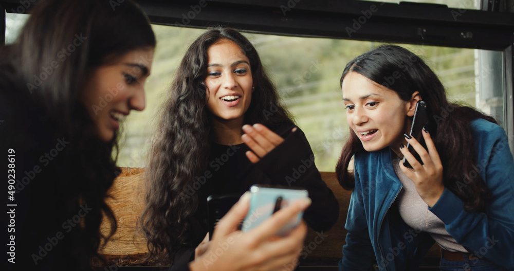 Wall mural Group of South Asian friends laughing together at a phone - friendship concept