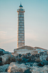 Vertical shot of the lighthouse of Punta Cavazzi in Ustica, Italy against a colorful evening sky