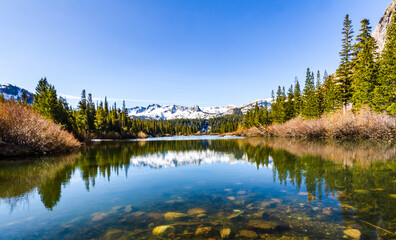 Fototapeta na wymiar Snow-capped mountains reflected on pond in Mammoth Lakes, California.
