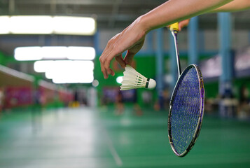 a man start the game by serving a shuttlecock,badminton playing concept.