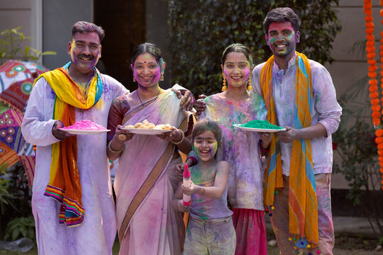 Indian family celebrating Holi together with colour