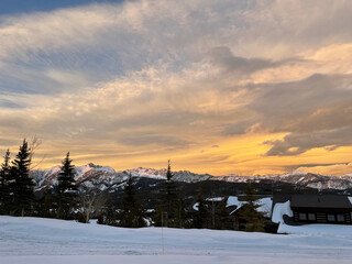 Golden sunset skies over Gallatin Peak as seen from Big Sky, Montana on a winter day