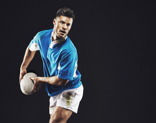 Time for a try. Studio shot of a rugby player passing the ball against a black background. - Powered by Adobe