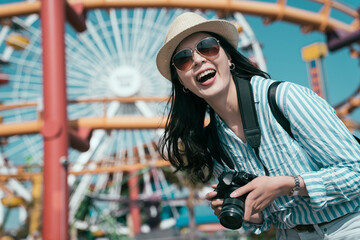 Happy hipster girl having fun on summer holiday. excited young asian japanese woman holding lens...