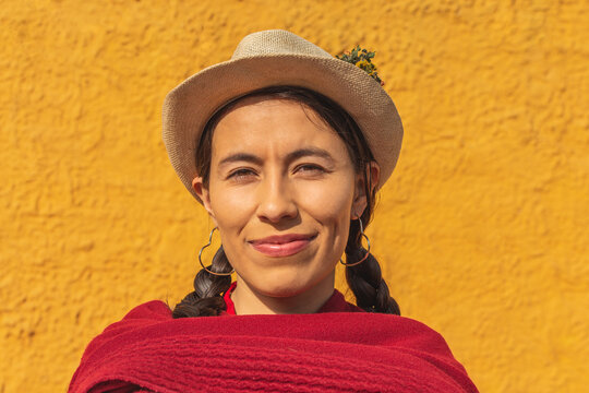 Close-up of the face of a latin indigenous woman with a hat and red shawl