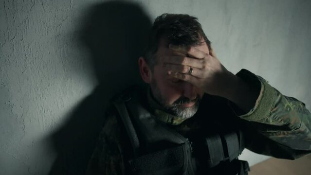 Frustrated military soldier sitting and crying alone in boot camp.
