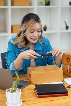 Small business SME entrepreneur of young Asian woman working with the laptop to shop online at home cheerfully and happy with boxes at home. personal business ready to send vertical images