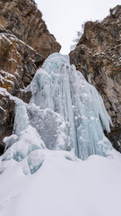 Fototapeta na wymiar Beautiful frozen waterfall in a mountain gorge