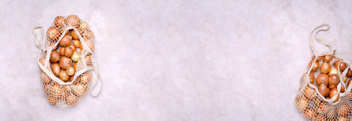 Fresh yellow onions in a knitted bag