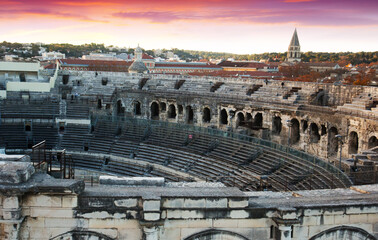 Naklejka premium Exterior of Arena of Nimes at sunset, ancient Roman amphitheater in France