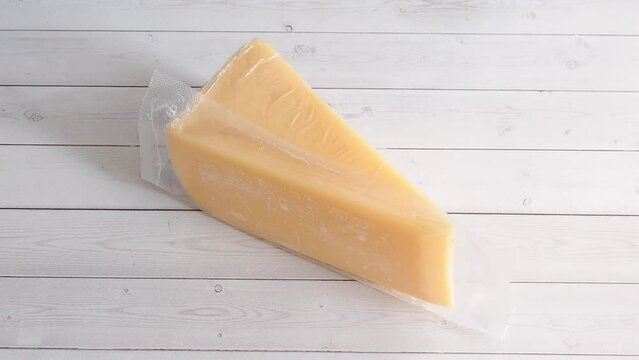 Soft cheese in vacuum packaging is placed on the table. A piece of cheese is packed for long-term storage and transportation.