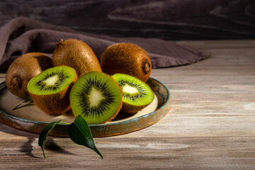 Kiwi in a plate on a wooden table.