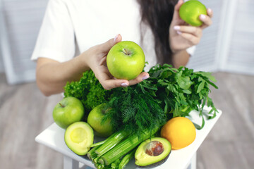 Woman with vegetables and fruits. Pineapple, apples and celery. The concept of spring and vitamins. Detox food. Front view.