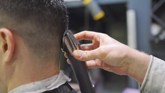 nape. hairdresser makes a haircut for a man with a hair clipper in a barbershop