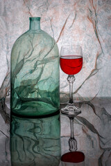 Still life with a glass jar and a glass of red wine.