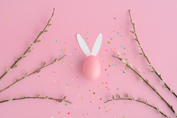 Easter bunny egg, confetti, pussy willow on a pink background.  Easter banner with space for text