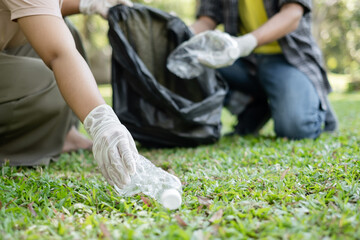 garbage collection, volunteer team pick up plastic bottles, put garbage in black garbage bags to clean up at parks, avoid pollution, be friendly to the environment and ecosystem