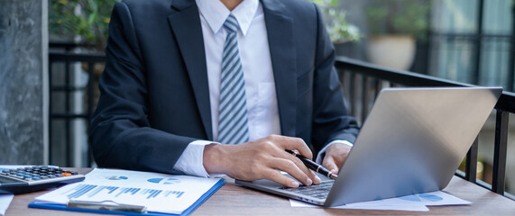 Young businessman financial market analyst sits at their desks and calculate financial graphs showing the results of their investments planning the process of successful business growth