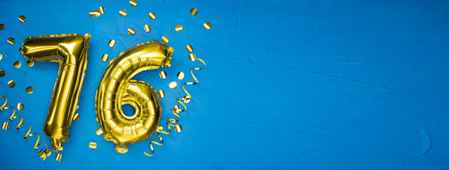 golden yellow foil balloon on blue concrete background number seventy six. Birthday or anniversary card with 76 inscription. Anniversary celebration. - obrazy, fototapety, plakaty