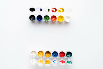 Flat composition a set of multi-colored paints in jars. Space for the text.
