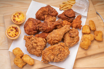 Fried chicken Crispy Chicken, Soft Chicken on wooden background, Fried chicken set with nuggets, french fries and egg tart.