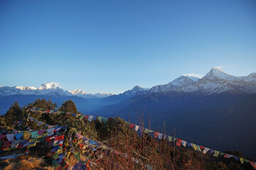 Natural landscape of Snowcapped mountain view of Poon hill with colorful prayer flags and blue sky, Annapurna Himalayan range- Ghorepani, Nepal