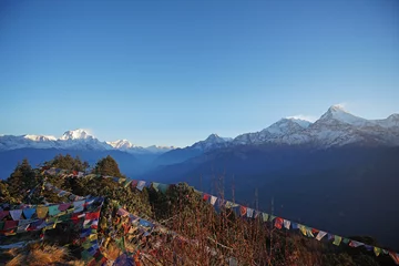 Papier Peint photo Annapurna Natural landscape of Snowcapped mountain view of Poon hill with colorful prayer flags and blue sky, Annapurna Himalayan range- Ghorepani, Nepal