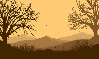 An beautiful mountain panorama at dusk from outside the village with aesthetic silhouettes of big dry trees