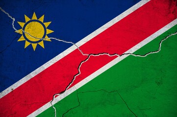 An image of the Namibia flag on a wall with a crack.
