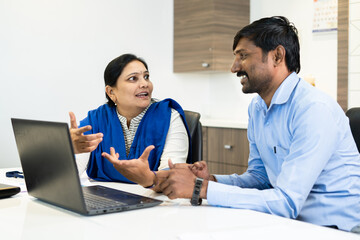 businesswoman explaining to colleague at office meeting - concept of teamwork, leadership and...