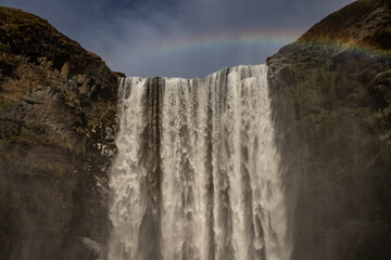 Cascada con arco iris y cielo azul