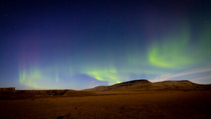 Fototapeta na wymiar Aurora boreal con montañas de fondo en noche estrellada
