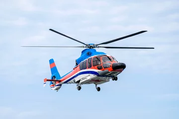 Zelfklevend Fotobehang Een helikopter vliegt in de lucht. © Vladimir