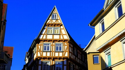 schmaler alter Fachwerkgiebel zwischen Häusern in der Altstadt von Esslingen am Neckar unter blauem Himmel