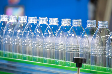 The empty PET bottles  on the conveyor belt for filling process in the drinking water factory.