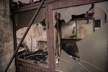 Fototapeta na wymiar Broken glass on old back door of workshop and garage in house caused by explosion.