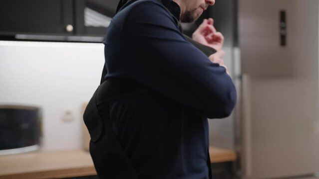 Headless male person in dark blue collar shirt put on posture belt 4K